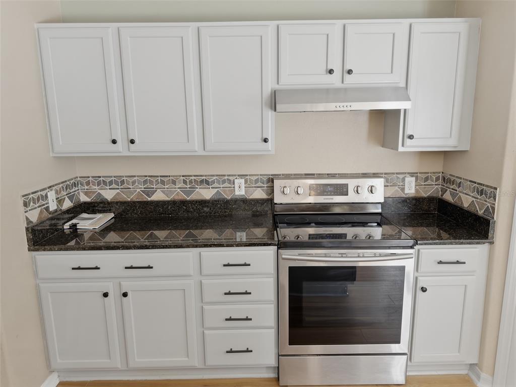 13302 Mitten Lane Spring Hill, FL 34609 - Photo 17 of 59 a kitchen with white cabinets and appliances