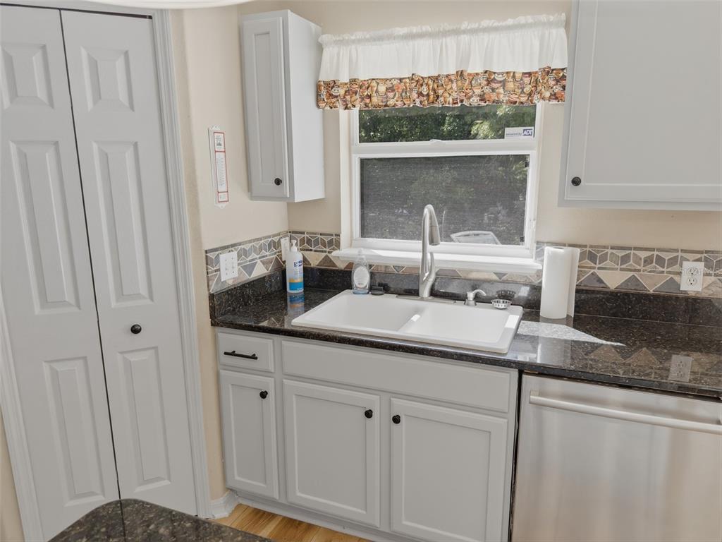 13302 Mitten Lane Spring Hill, FL 34609 - Photo 18 of 59 a bathroom with a granite countertop sink and a mirror