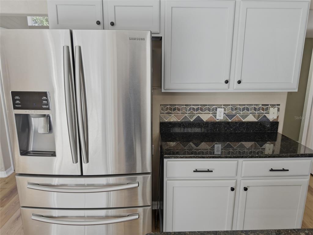 13302 Mitten Lane Spring Hill, FL 34609 - Photo 19 of 59 a kitchen with granite countertop white cabinets and stainless steel appliances