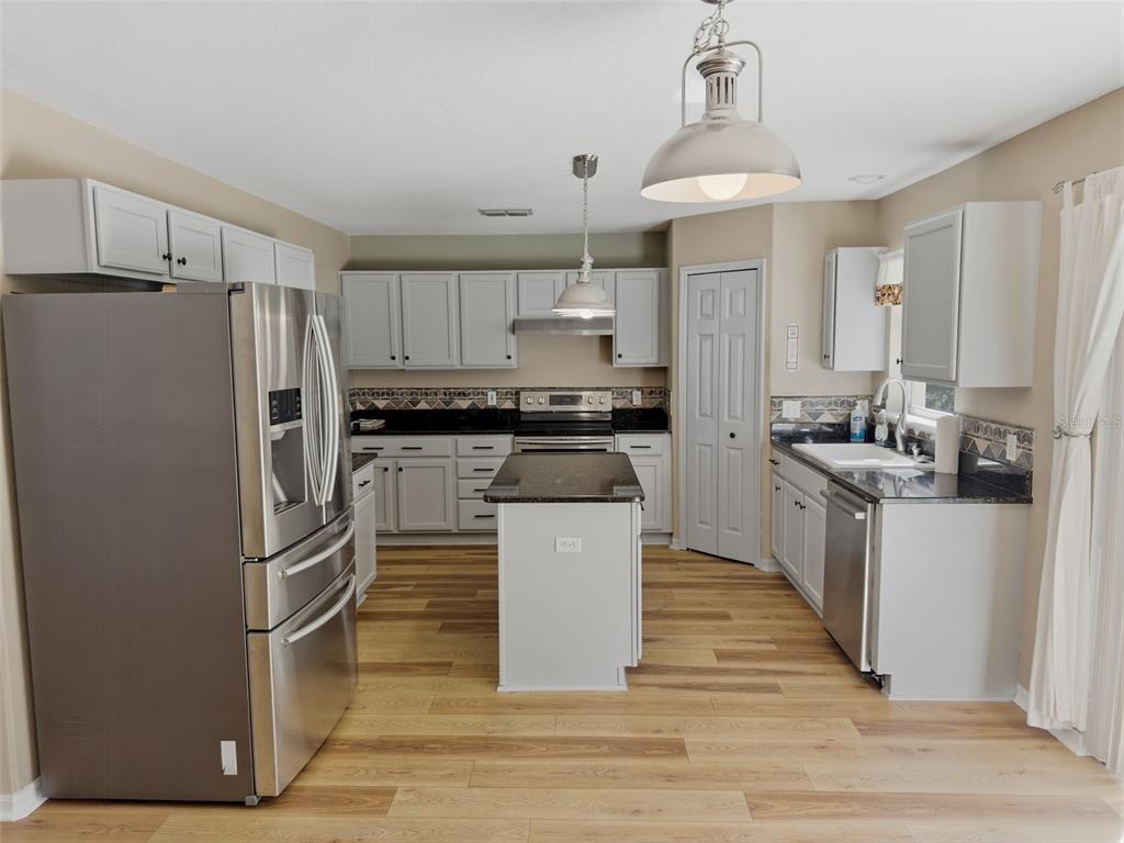 13302 Mitten Lane Spring Hill, FL 34609 - Photo 20 of 59 a kitchen with stainless steel appliances a refrigerator and a stove