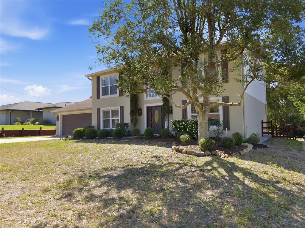 13302 Mitten Lane Spring Hill, FL 34609 - Photo 2 of 59 a front view of a house with a yard and garage
