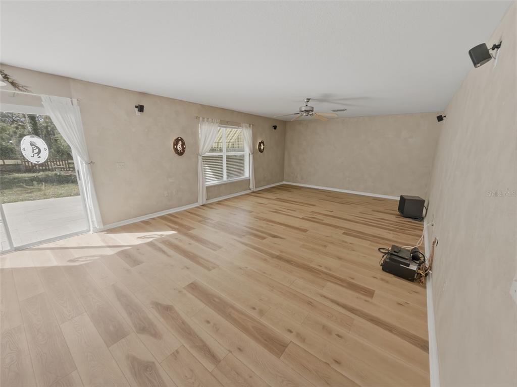 13302 Mitten Lane Spring Hill, FL 34609 - Photo 22 of 59 a view of empty room with a fireplace and wooden floor