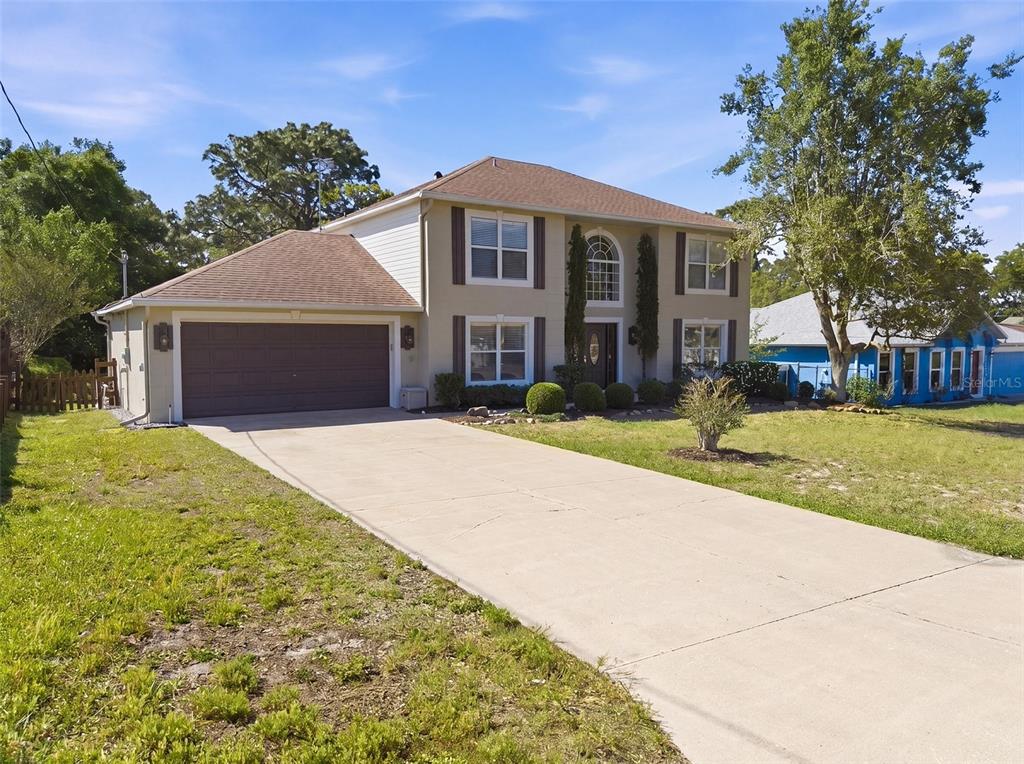 13302 Mitten Lane Spring Hill, FL 34609 - Photo 3 of 59 a front view of a house with a yard