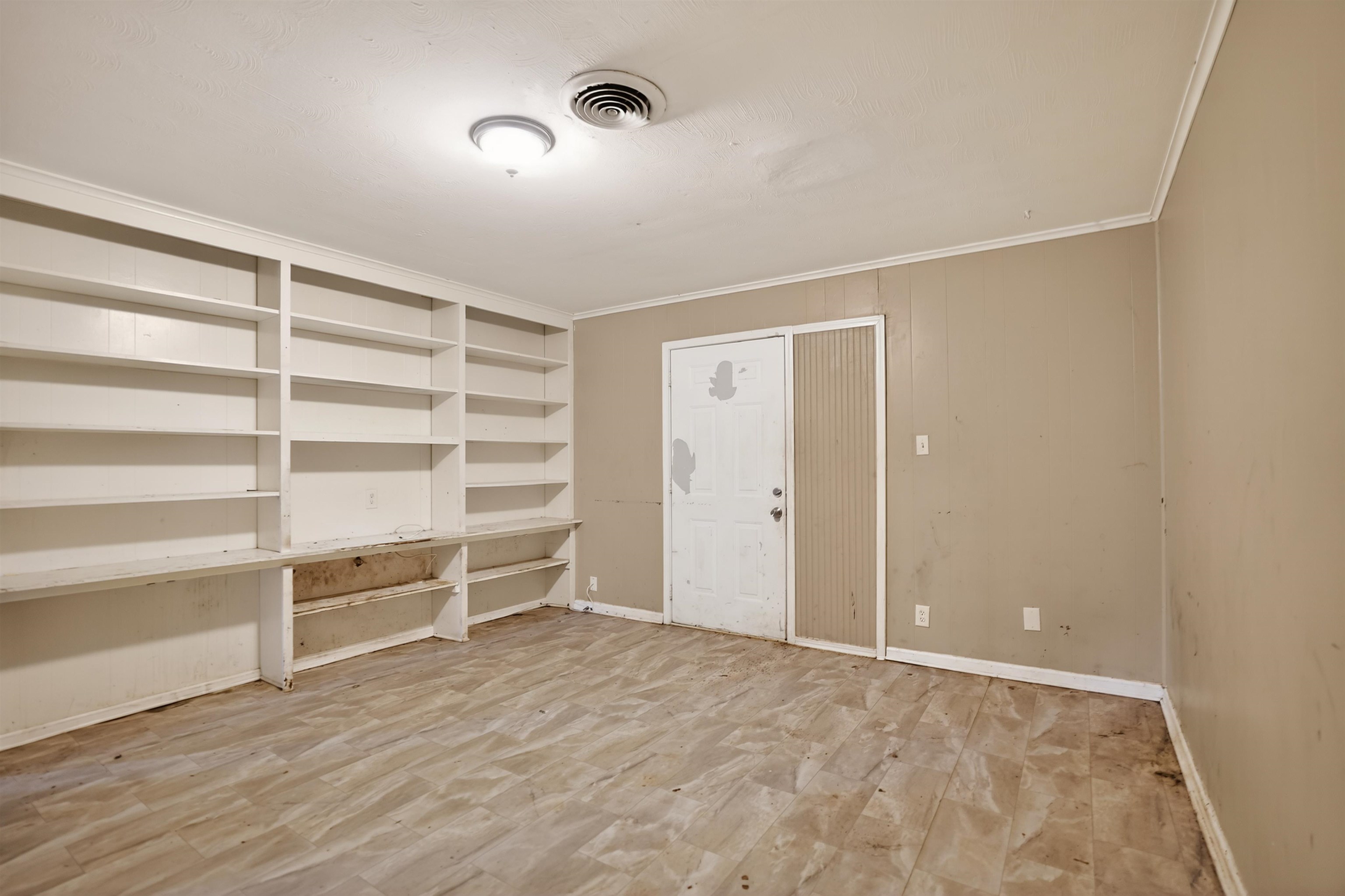 1890 Pennel Road Memphis, TN 38116 - Photo 5 of 25 Interior room featuring extensive built-in shelving, wood-finish flooring, and painted walls