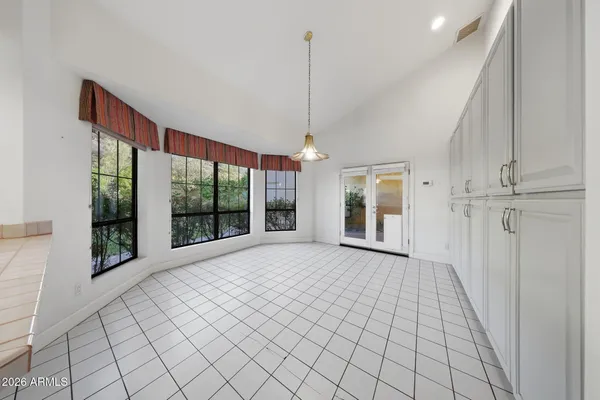 a view of an empty room with fireplace stairs and windows
