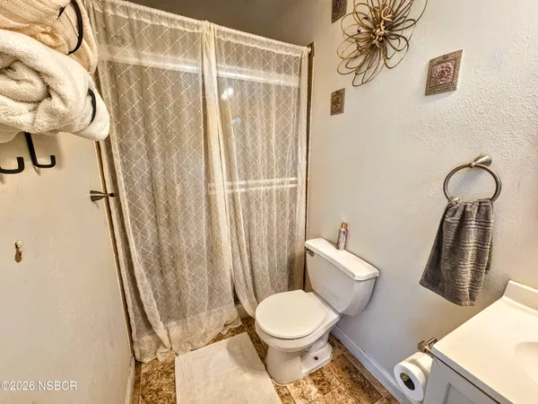a white toilet sitting next to a shower curtain