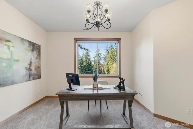 a view of a workspace with a table and a potted plant