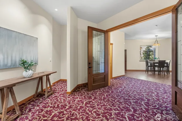 a view of a hallway and dining room with furniture