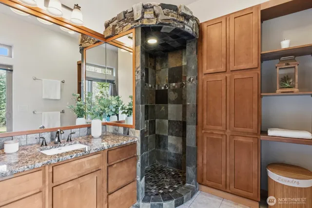 a bathroom with a granite countertop sink toilet and shower