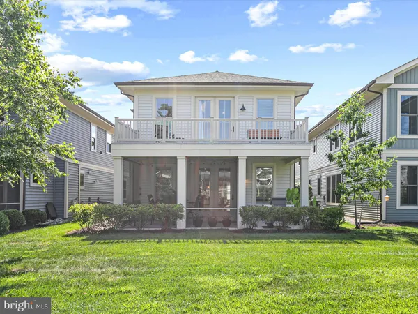 a front view of a house with a yard and potted plants