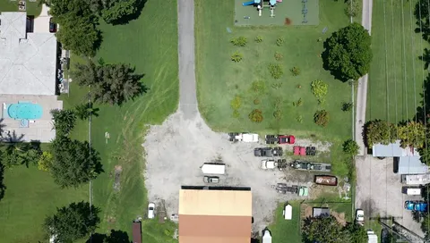 an aerial view of residential house with outdoor space and trees all around