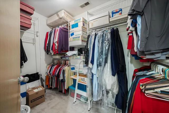 a view of walk in closet with clothes