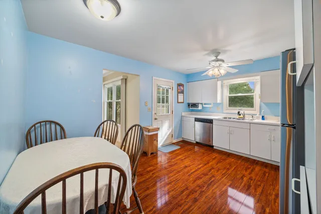 a kitchen with stainless steel appliances granite countertop a stove a sink a refrigerator dining table and chairs