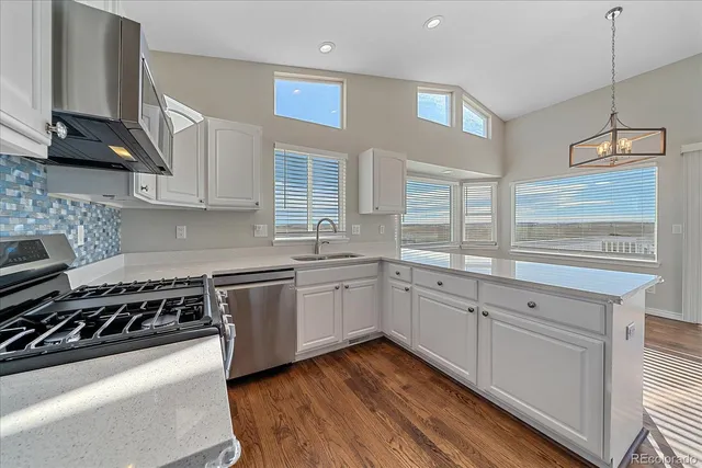 a kitchen with a white cabinets and wooden floor