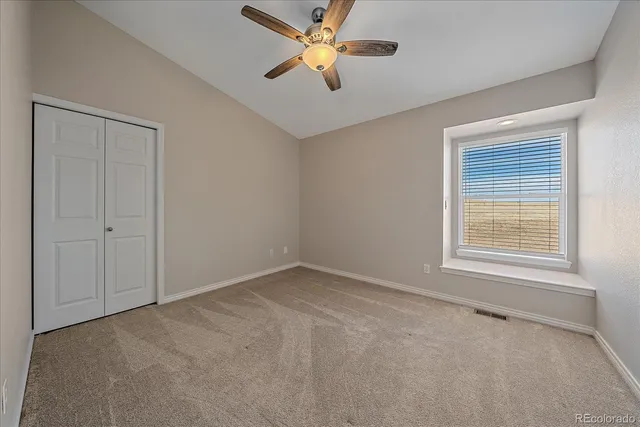 an empty room with a window and a fan