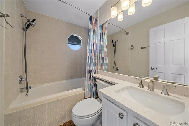 a bathroom with a sink a toilet a mirror and shower