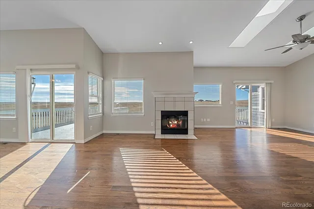 a view of a livingroom with wooden floor and a fireplace