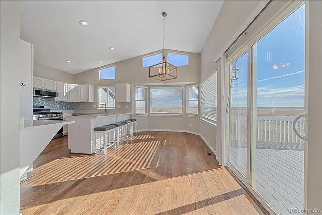 a kitchen view with granite countertop wooden floor a center island cabinets and appliances