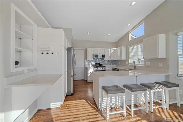 a kitchen with a dining table chairs refrigerator and cabinets