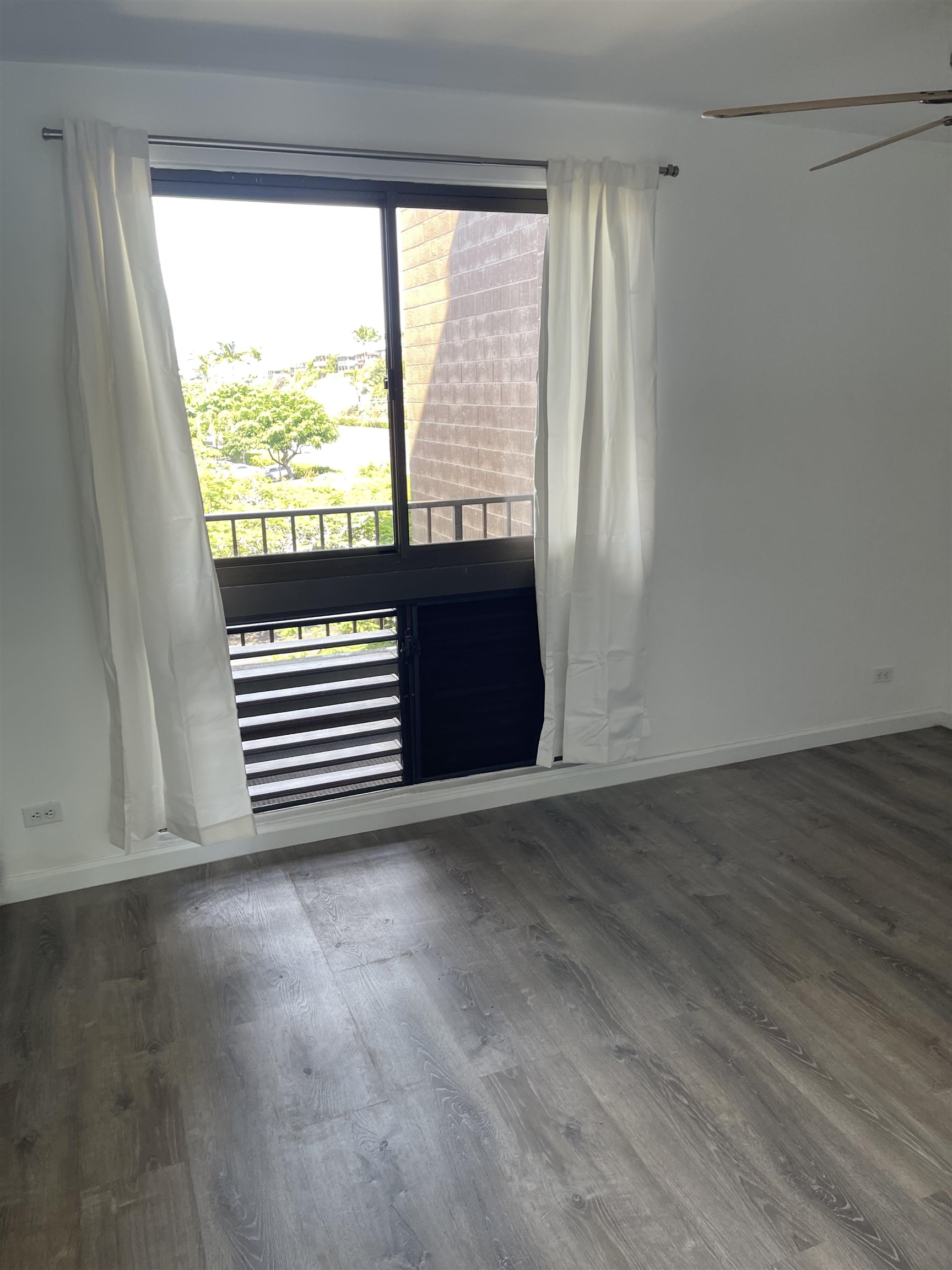 4310 Lower Honoapiilani Road, Unit 516 Lahaina, HI 96761 - Photo 8 of 16 an empty room with wooden floor and windows