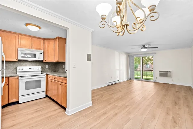 a kitchen with stainless steel appliances granite countertop a stove a sink and a microwave oven with white cabinets