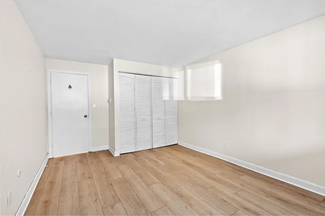 a view of an empty room with wooden floor
