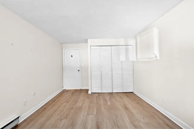 a view of an empty room with wooden floor