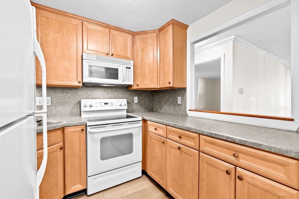 79 Fountain Lane, Unit 3 Weymouth, MA 02190 - Photo 5 of 29 a kitchen with granite countertop cabinets stainless steel appliances and a sink