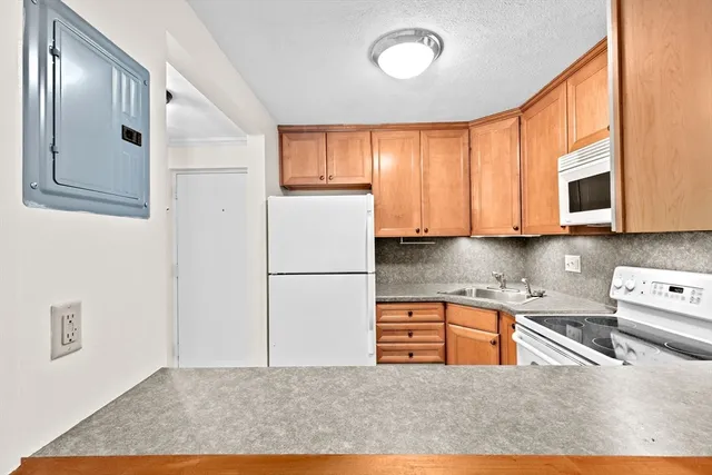 a kitchen with stainless steel appliances granite countertop a refrigerator a stove top oven and sink