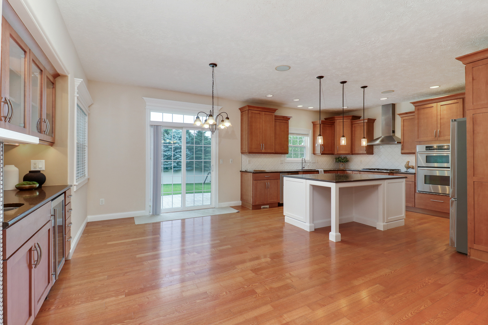 69 Brookstone Circle Bloomington, IL 61704 - Photo 17 of 63 a kitchen with kitchen island granite countertop a stove a sink a center island and wooden floor