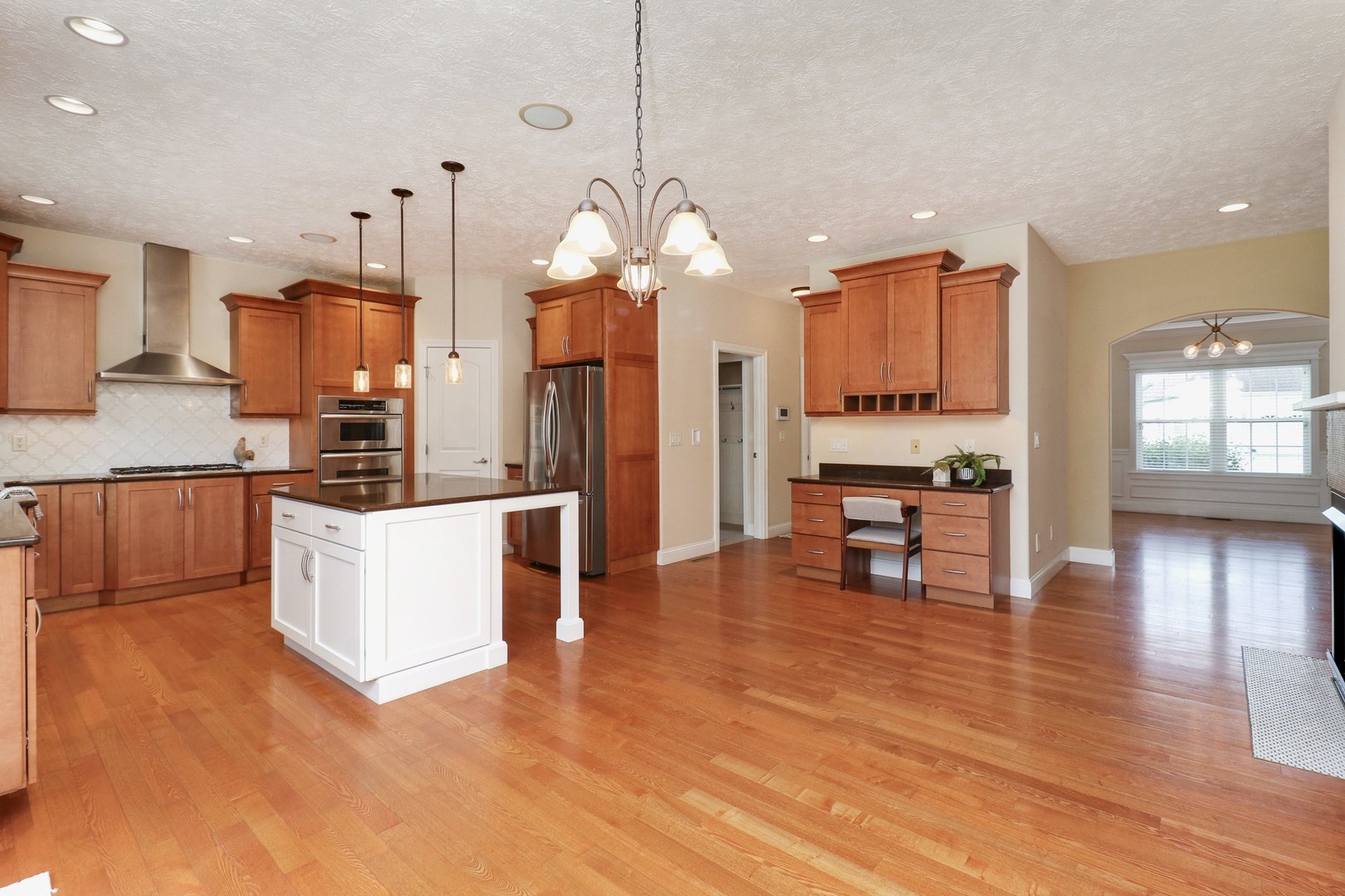 69 Brookstone Circle Bloomington, IL 61704 - Photo 19 of 63 a kitchen with stainless steel appliances kitchen island granite countertop a stove a refrigerator and a wooden floors