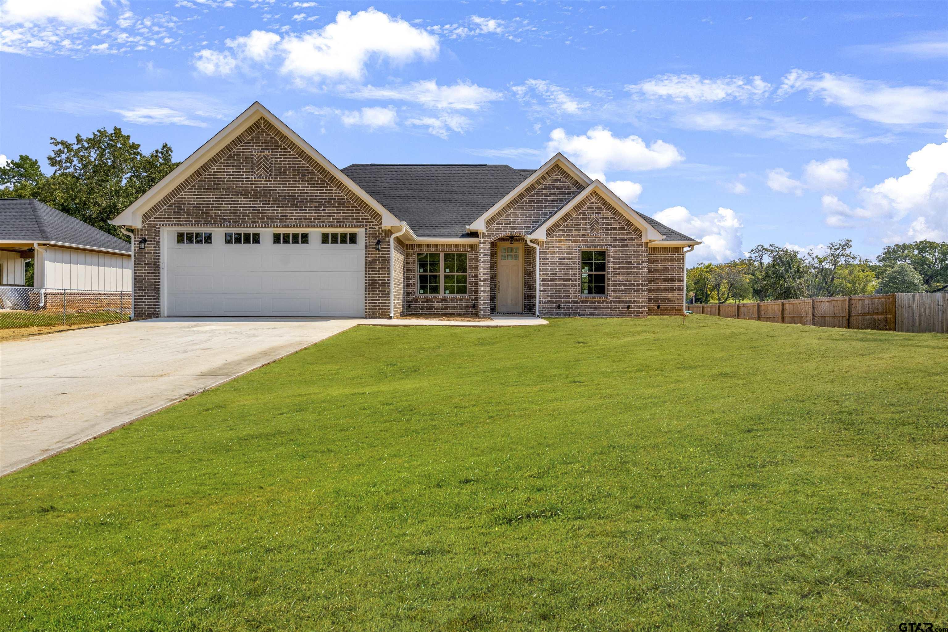 a front view of a house with yard and green space