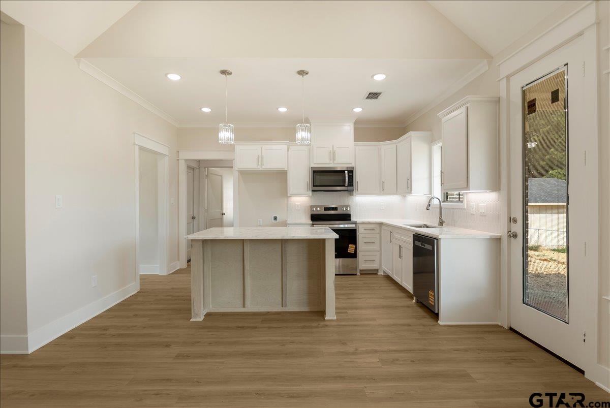 501 County Road 330 Tyler, TX 75708 - Photo 13 of 36 a large kitchen with kitchen island wooden floors appliances and white cabinets