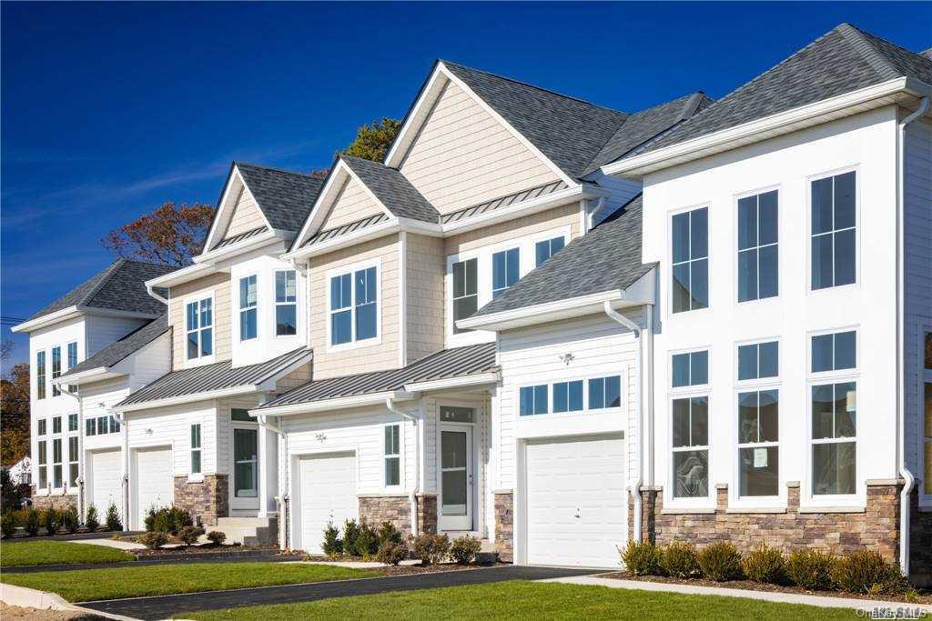 1239 Old Nichols Road, Unit 8 Islandia, NY 11749 - Photo 1 of 1 a front view of a residential apartment building with a yard