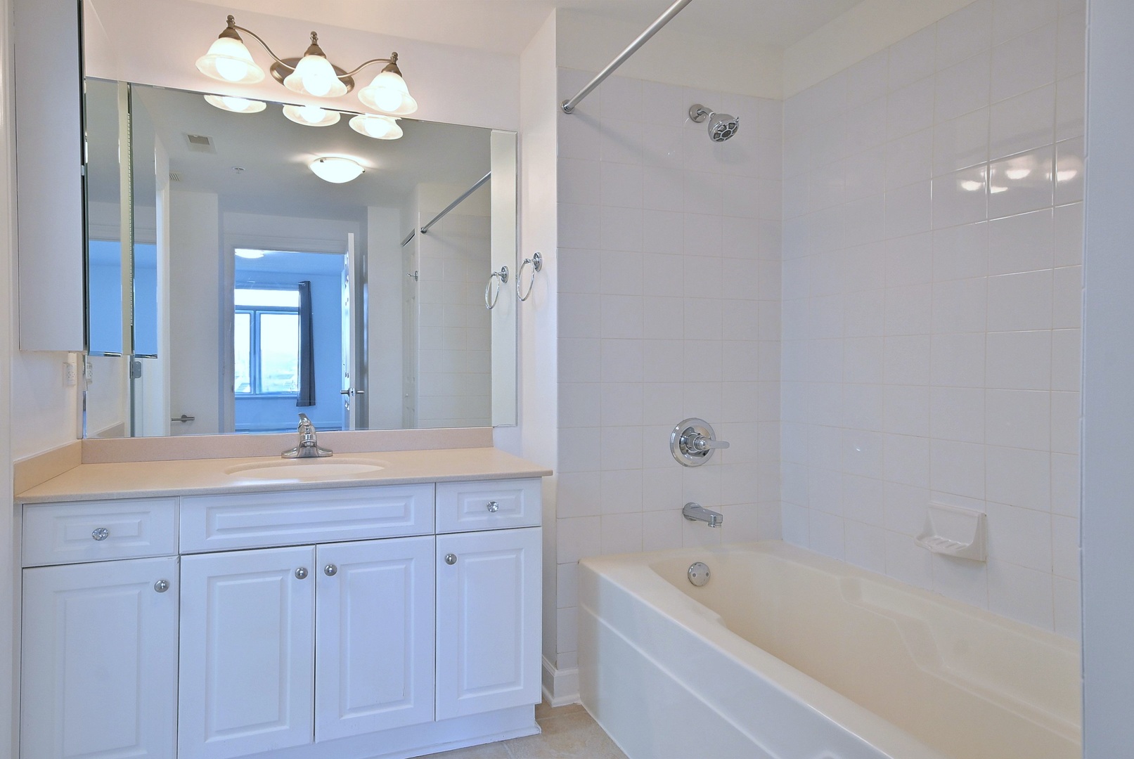 8300 Callie Avenue, Unit 412 Morton Grove, IL 60053 - Photo 15 of 28 a bathroom with a bathtub a sink and a mirror