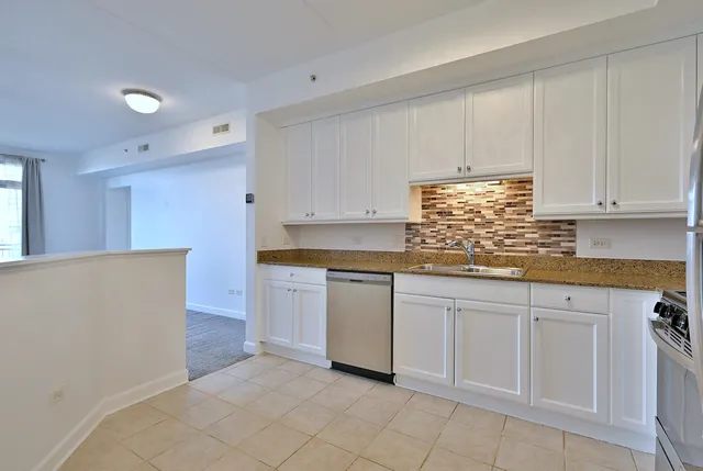 a kitchen with granite countertop white cabinets and white appliances