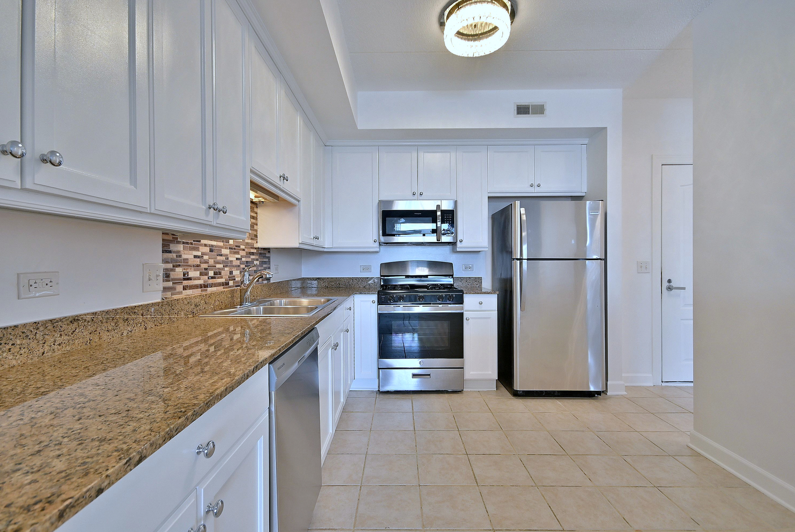 8300 Callie Avenue, Unit 412 Morton Grove, IL 60053 - Photo 9 of 28 a kitchen with a refrigerator sink and cabinets