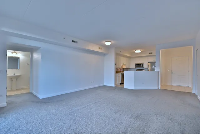 a view of an empty room with a kitchen
