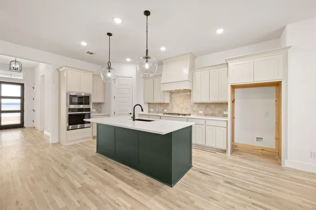 a large kitchen with stainless steel appliances kitchen island a large counter top and a sink