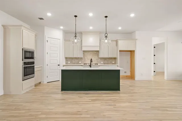 a view of kitchen with kitchen island stainless steel appliances sink refrigerator and stove