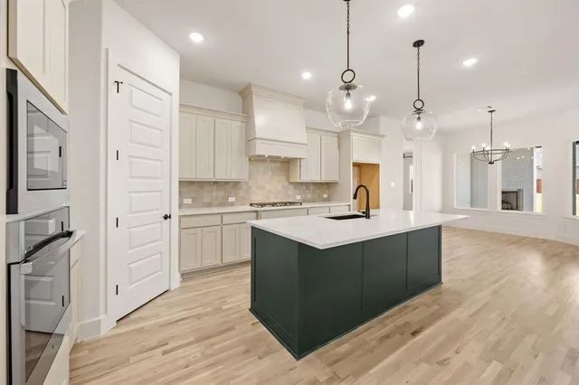 a kitchen with kitchen island a sink stainless steel appliances and cabinets