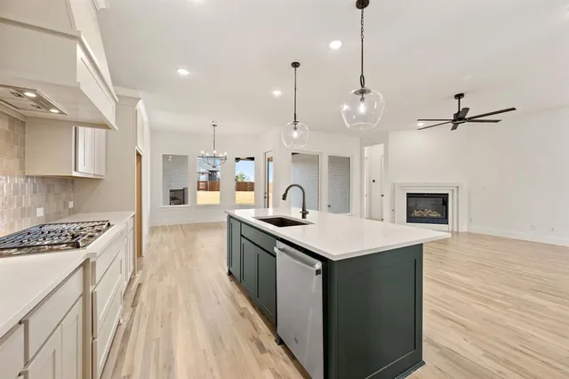 a kitchen with kitchen island a sink appliances and cabinets