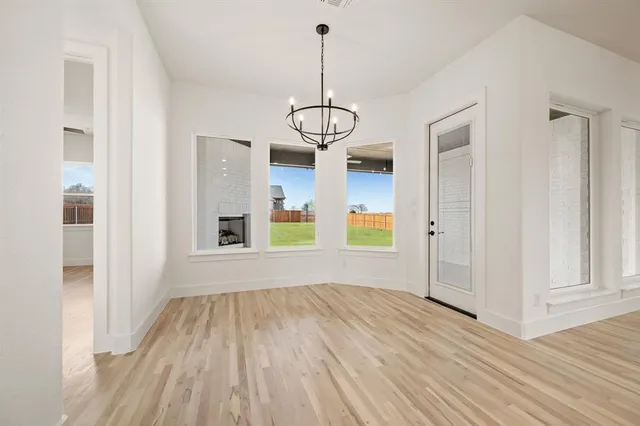 a view of empty room with wooden floor and windows