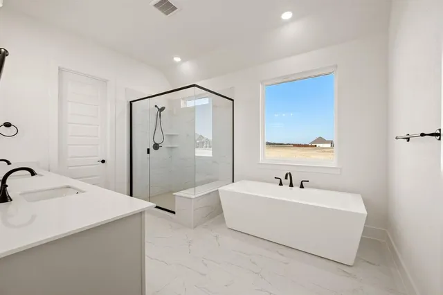 a bathroom with a tub a sink shower and mirror
