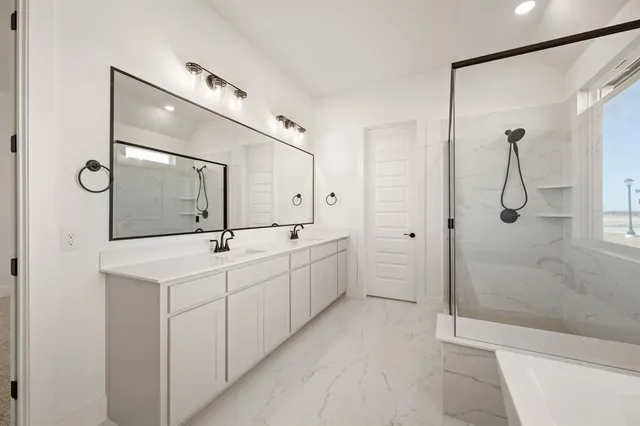 a spacious bathroom with a double vanity sink mirror and shower