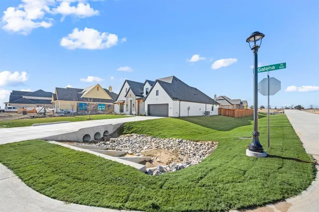 a view of a house with a big yard and potted plants