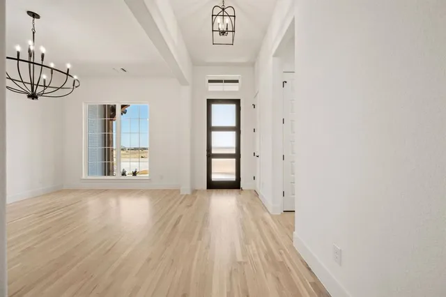 a view of a hallway with wooden floor and closet