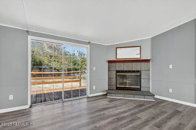 a view of an empty room with a window and fireplace