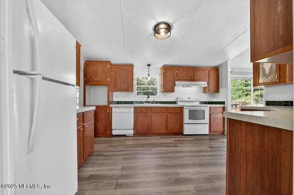 a large kitchen with stainless steel appliances granite countertop a stove a sink dishwasher and a refrigerator