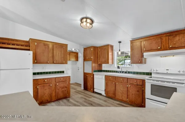 a kitchen with stainless steel appliances granite countertop a stove a sink dishwasher and a refrigerator
